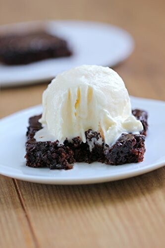 Brownie topped with vanilla ice cream on a plate.