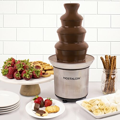 Chocolate fountain with strawberries, cookies, bananas, and pretzels.