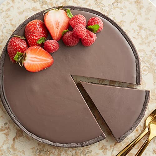 Chocolate tart with a slice cut out, topped with strawberries and raspberries.